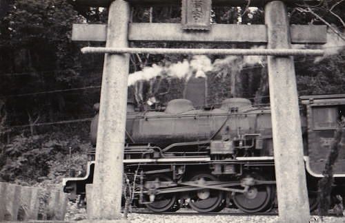 福岡県みやこ町　　「　鳥居の間に敷かれた線路の上を列車が走る　」