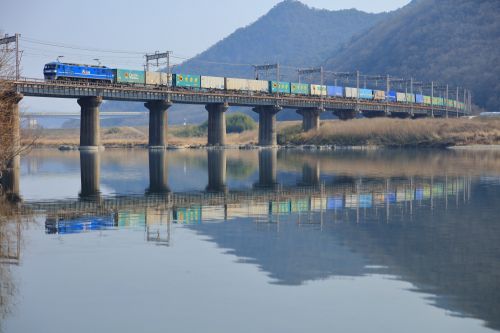 山陽本線の吉井川の水鏡に映るＥＦ２１０牽引のコンテナ貨物と１１５系ローカル電車（熊山～万富）