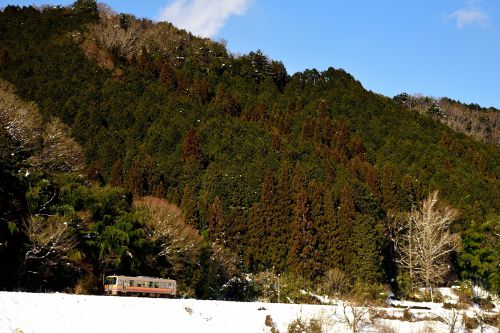因美線の雪景色の里山をのんびりと進むキハ１２０形ローカル列車（那岐～土師）